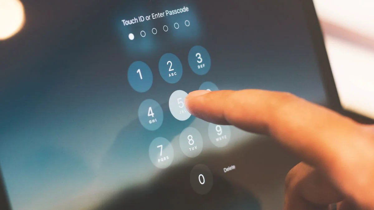 Telefoon met tweestapsverificatie naast een open laptop