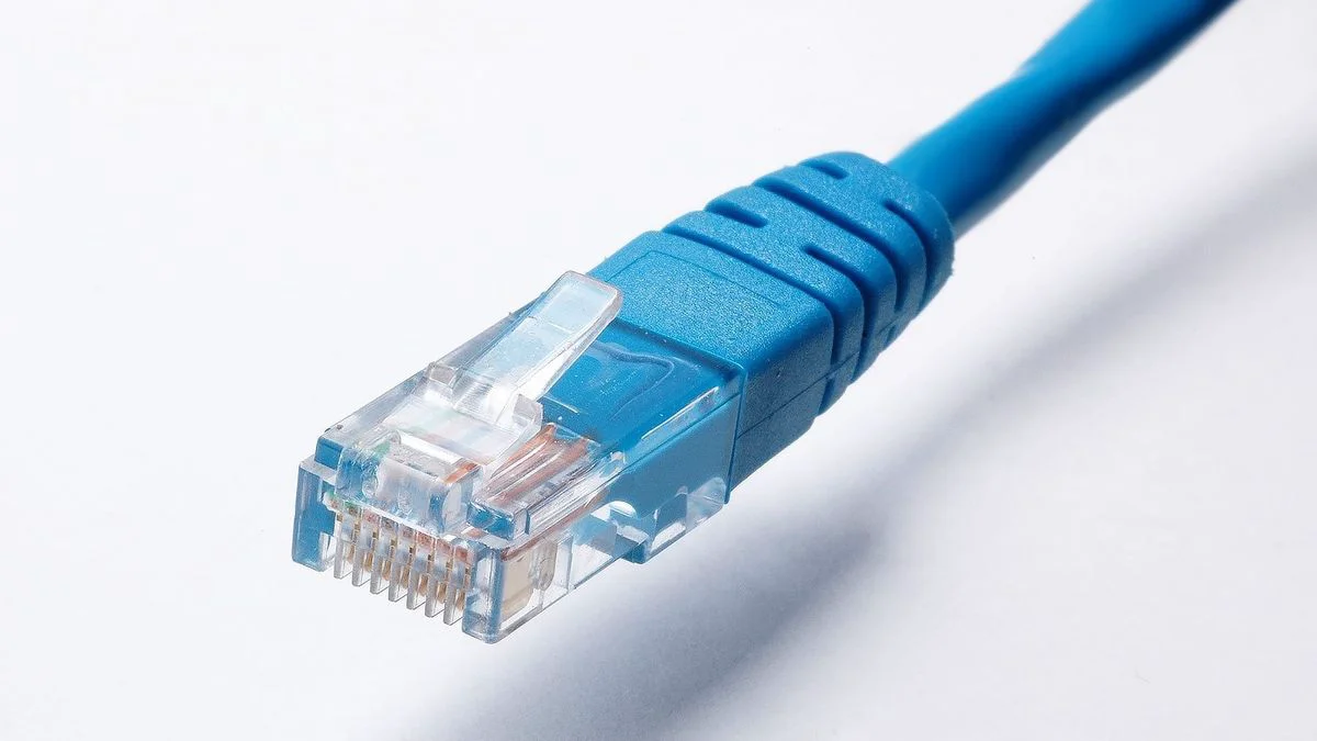 Hand trekt een netwerkkabel uit een laptop om verbinding te verbreken