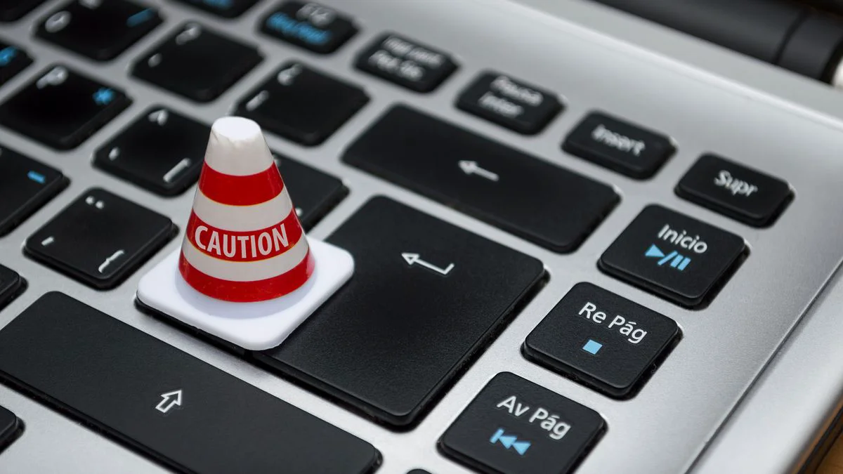 Gebruiker kijkt naar een trage computer met waarschuwing op het scherm
