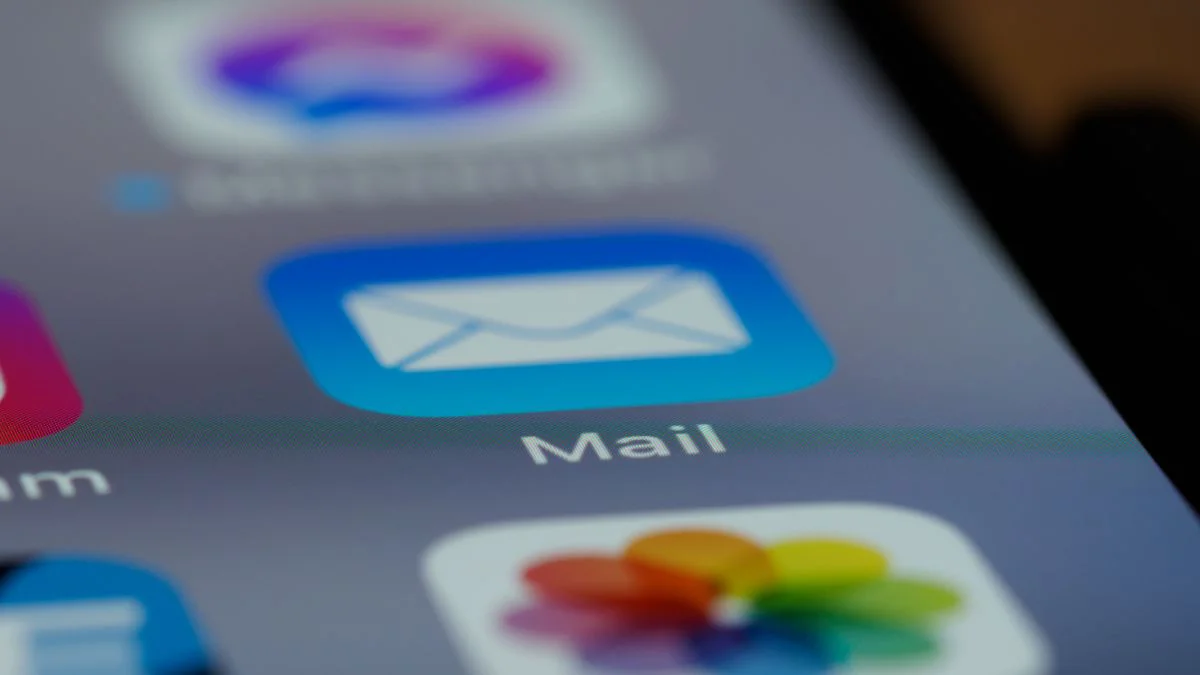 Hand die een smartphone vasthoudt met een e-mailapp en beveiligingsmelding