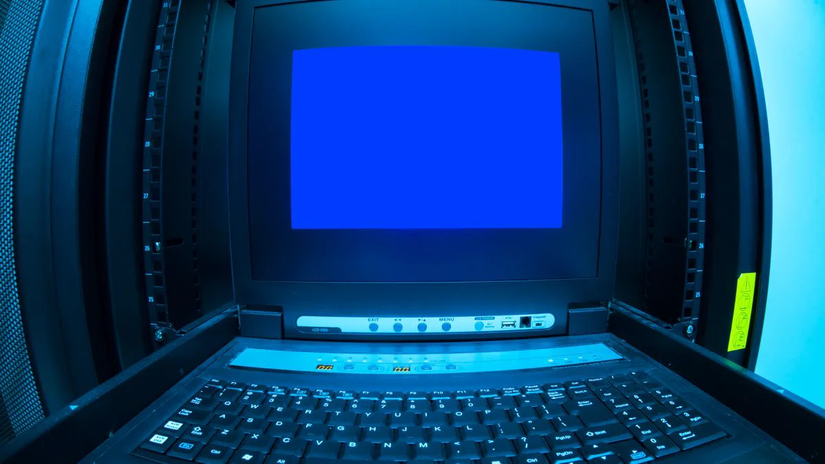 Beheerder bekijkt beveiligingsmeldingen op een laptop naast serverapparatuur