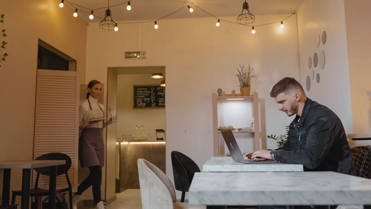 Persoon gebruikt een laptop in een café met openbaar wifi-netwerk