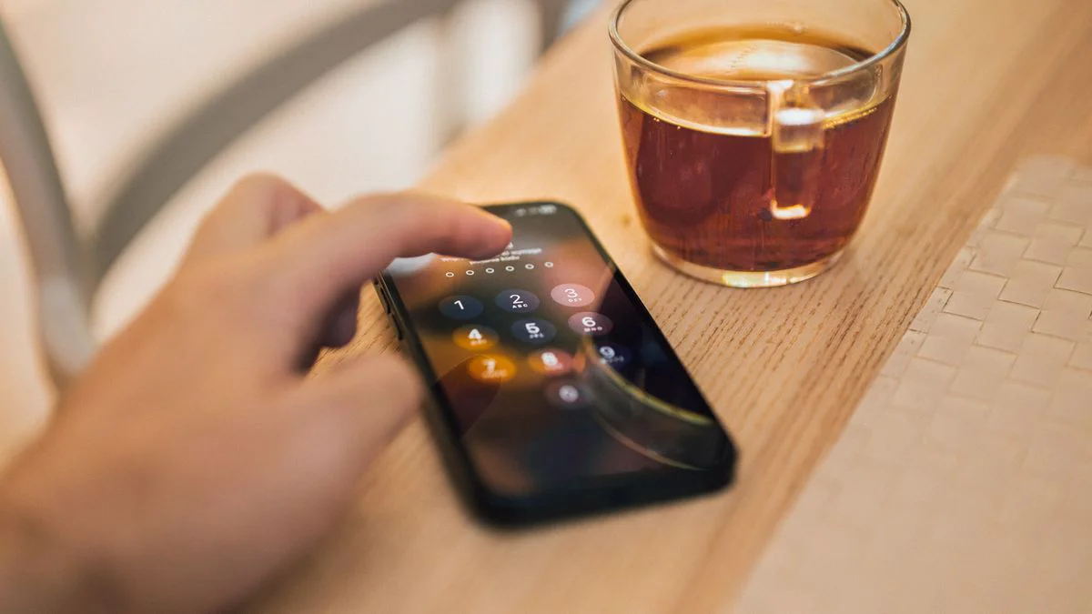Smartphone met inlogscherm en tweestapsverificatie op een bureau