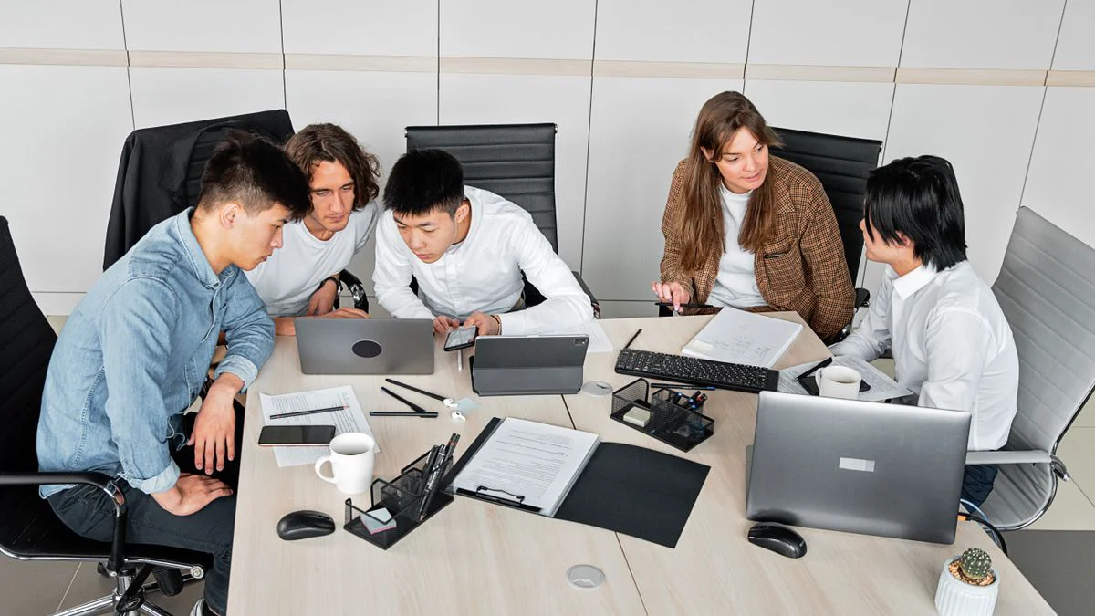 IT-medewerkers bespreken werkzaamheden naast een laptop op kantoor.