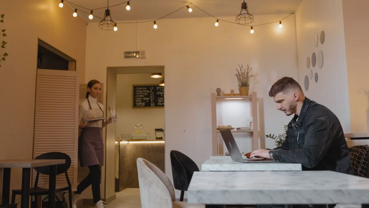 Persoon werkt op een laptop in een café met openbare wifi