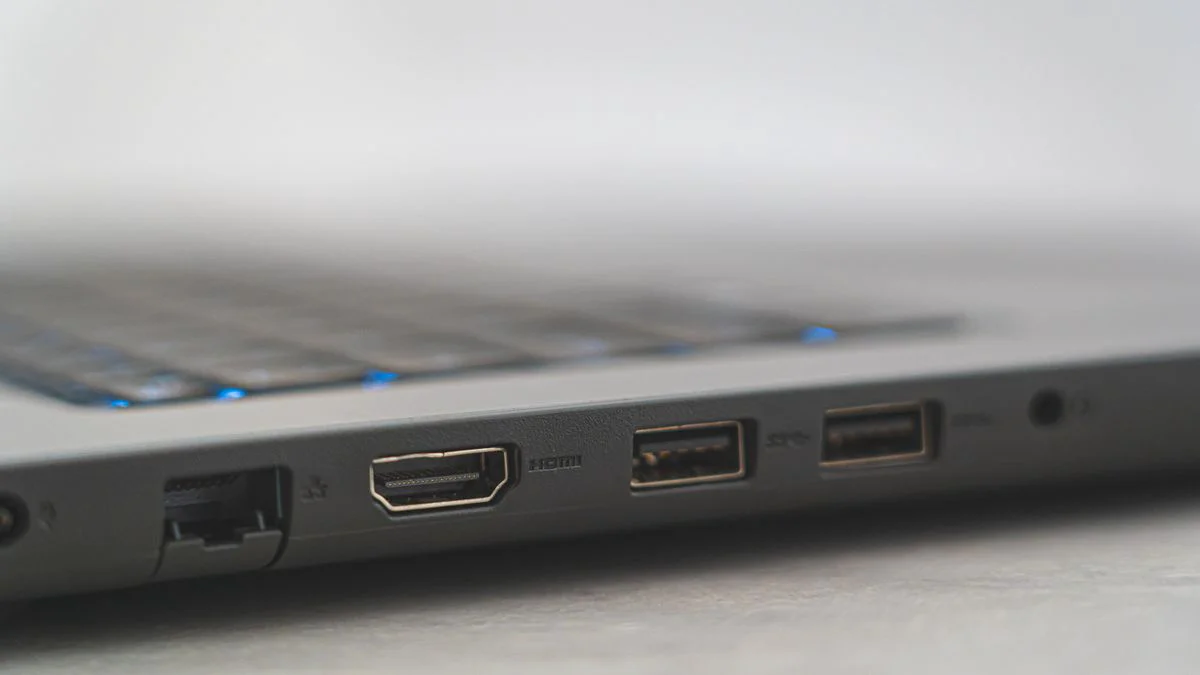 Hand naast een laptop met een aangesloten netwerkkabel