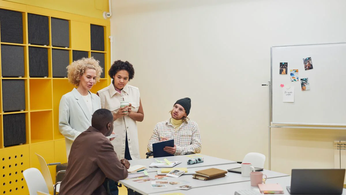 Een klein team bespreekt documenten en maakt aantekeningen tijdens een werkoverleg.