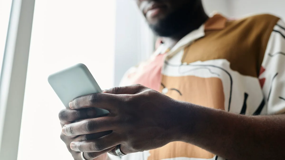 Hand die een smartphone vasthoudt met een webpagina op het scherm