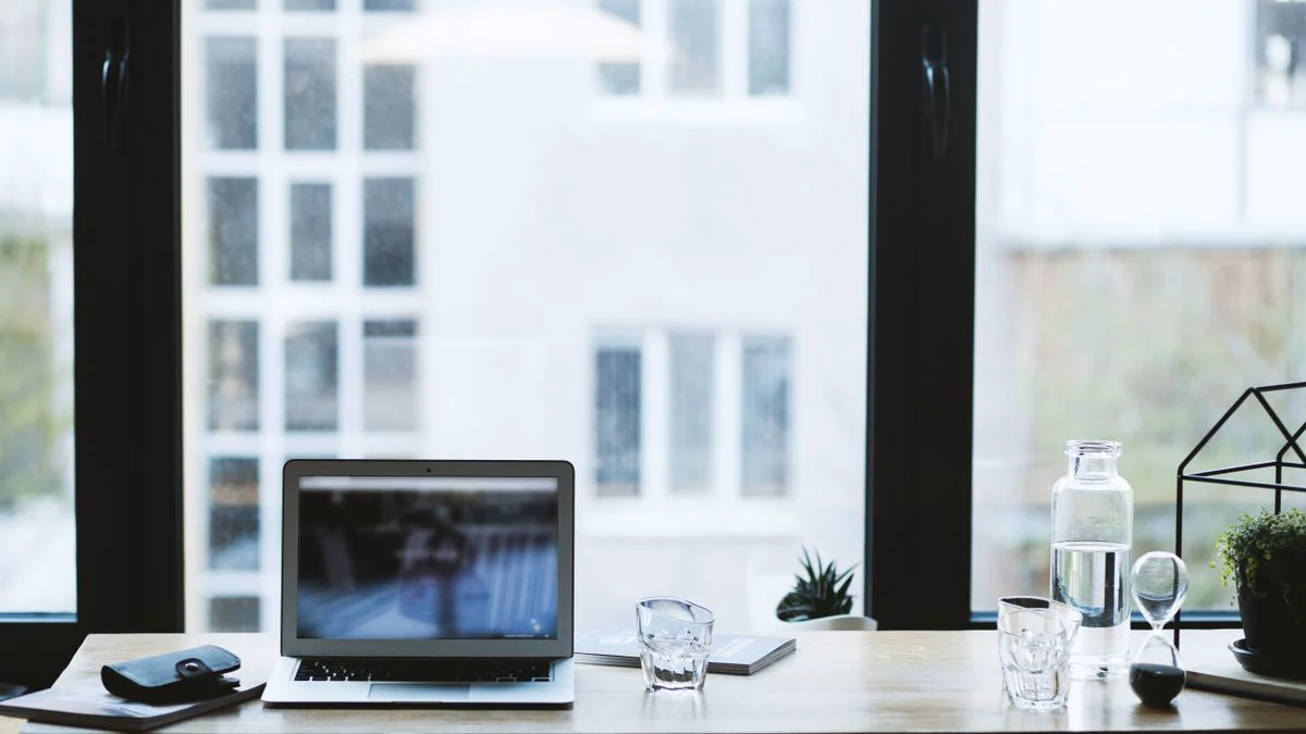 Laptop op een bureau met een stoel en werkmateriaal