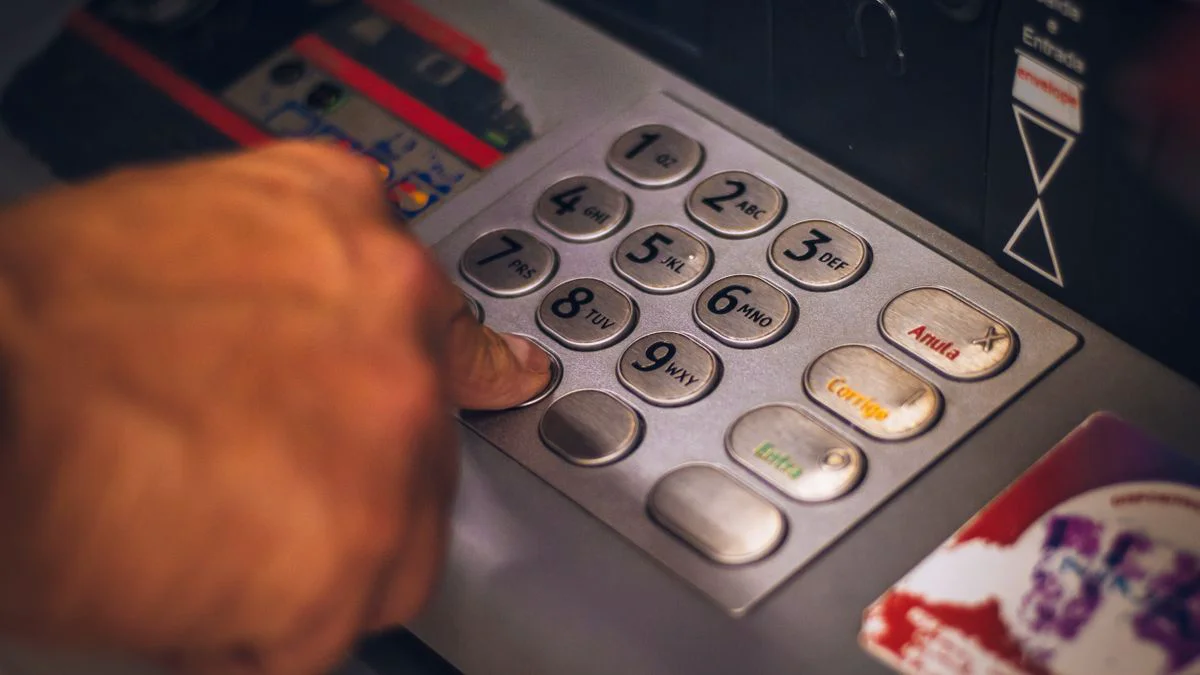 Persoon die tijdens het betalen de toetsen van een betaalautomaat met een hand afschermt