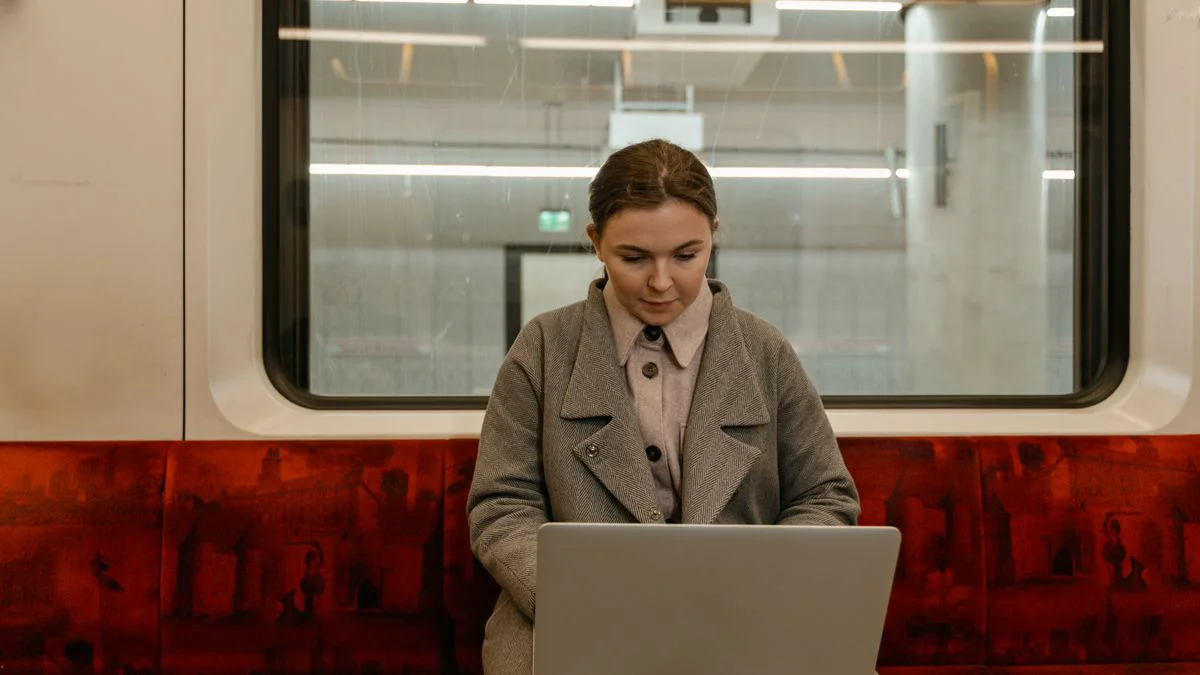 Reiziger met een geopende laptop aan een tafeltje in de trein